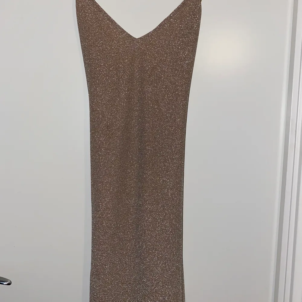 en super fin glitter klänningen med öppen rygg, säljer den då den inte kommer komma till andvädning, den är oanvänd bara testad, den är bekväm att ha på sig💘 frakten står man för själv (63kr). Klänningar.