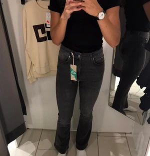 Gråa Bootcut Jeans - Grå bootcut Jeans från GinaTricot! Använda men i mycket bra skick! Osäker på om de är strl 34 elr 36 men passar mig som brukar ha 36. Är 170 cm lång. Kan mötas upp annars står köpare för frakt 💛