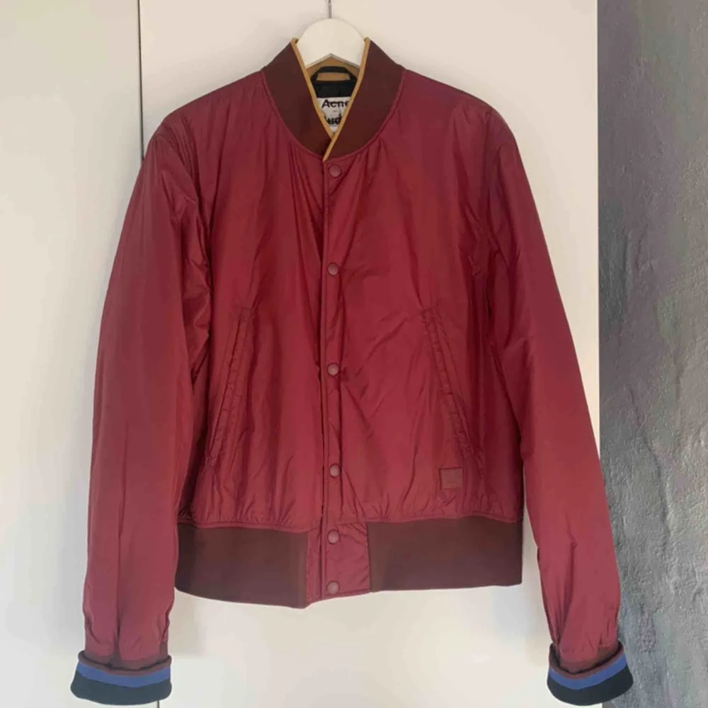 ACNE STUDIOS MILLS FACE BURGUNDY  Bomber/baseball-jacka från Acne Studios. Detta är ett sample så care label saknas på insidan. Fint skick. Face-logga i höger nederkant ovanför mudd. Nypris runt 3000 kr. Jackor.