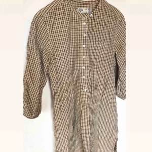  - Rutig och beige skjortklänning från JC Crocker. Fint skick. Gör sig fint med ett bälte i midjan. 