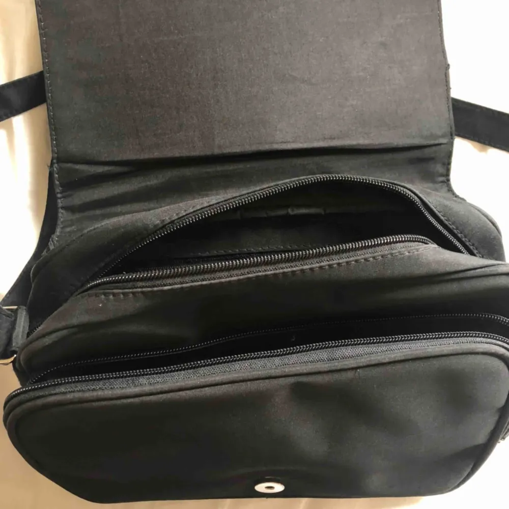 Jättecool svart handväska köpt second hand! Den har tre ytterfack på väskan och väskan i sig har två (se bild 3) Köpt på emmaus💜Köpare står för frakt! . Väskor.