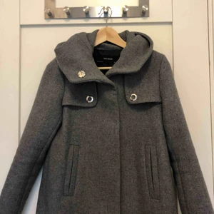 Zara jacka XS - Superfin grå kappa med luva från Zara. Använd en gång och i perfekt skick! Säljer p.g.a använder ej. Priser går att förhandla.