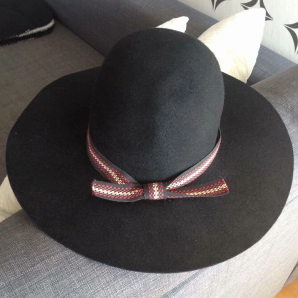 Svart hatt i ull prydd med ett snyggt band. Innermått 55 cm. Brettet mäter 36 cm på bredden och 39 cm på längden. Enda skavanken är att bandet släppt lite baktill, men det fixas lätt med lite lim! Porto 98 kr tillkommer (Shenker), alternativt upphämtning i Gävle.. Accessoarer.