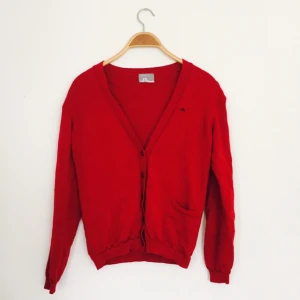  - Röd Cardigan, J.Lindeberg, strl medium.  Använd fåtal gånger, mycket mjuk och skön i materialet. 