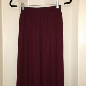 Klockad vinröd kjol i chiffong från american apparel med resår i midjan. Kjolen har två lager och blir därför inte genomskinlig. Längd: vadlång på någon som är ca 170cm 
