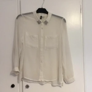  - Genomskinlig skjorta med diamant detaljer på kragen. Det är en 34 men är oversized så det skulle passa en 40 också. Jag är 38 och den är fortfarande oversized på mig. Den är 100% polyester, tvättas i 30 grader och kan strykas! Har swish, träffas i Jönköping eller fraktar, som köparen står för. Pris går att diskutera, det är ju ändå second hand!