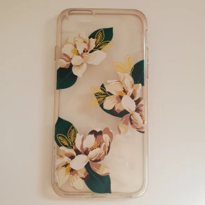  - Mobilskal till iPhone 6 (och andra mobiler som har samma modell som 6:an) i gummimaterial med blommor på. Fint skick! Något gul/mörk i plasten som man kan se på bilderna. 25kr+frakt