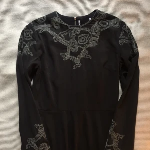  - svart klänning med coola broderier vid halsringning och ärmslut. köpt på emmaus vintage och aldrig använd av mig, fint skick. lapp med märke och storlek saknas men uppskattar den till en storlek S