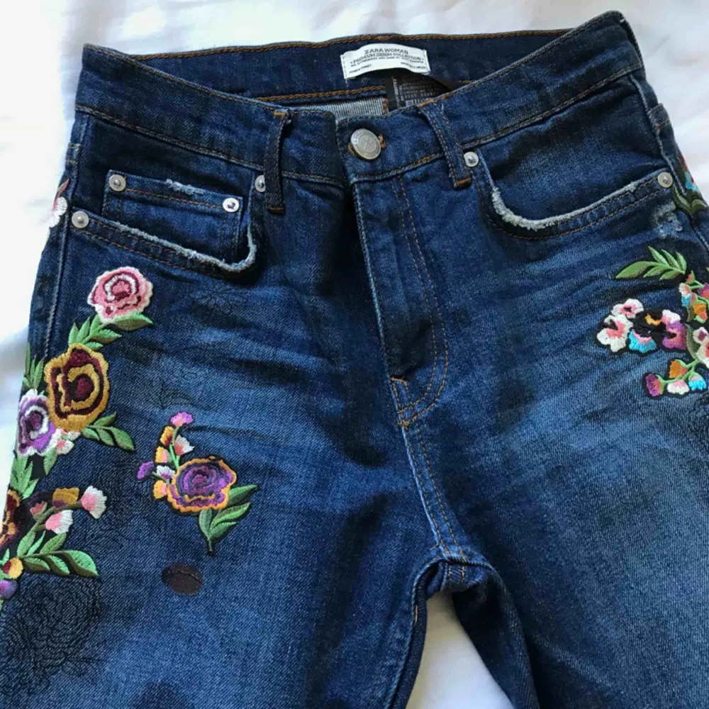 Ett par blåa ankeljeans från Zara med snygga blomdetaljer.  Byxorna är i storlek 34 eller XS och har endast använts två gånger. . Jeans & Byxor.