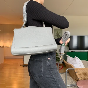 Grå väska  - Jag säljer denna superfina gråa väskan som blivit köpt utomlands men sedan aldrig använd. Den är i nyskick. Väskan är rymlig och har många fack/fickor på insidan. 💞 köparen står för frakten men jag möter även upp i Lund💞 