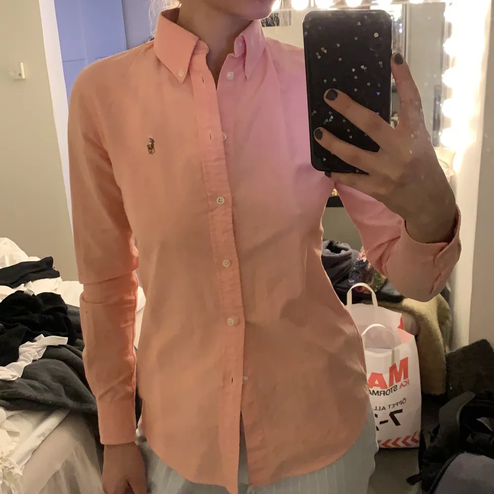 En persikofärgad skjorta från Polo Ralph Lauren i strl XS. Endast använd ett par gånger så i bra skick. Säljer då den aldrig används.. Skjortor.
