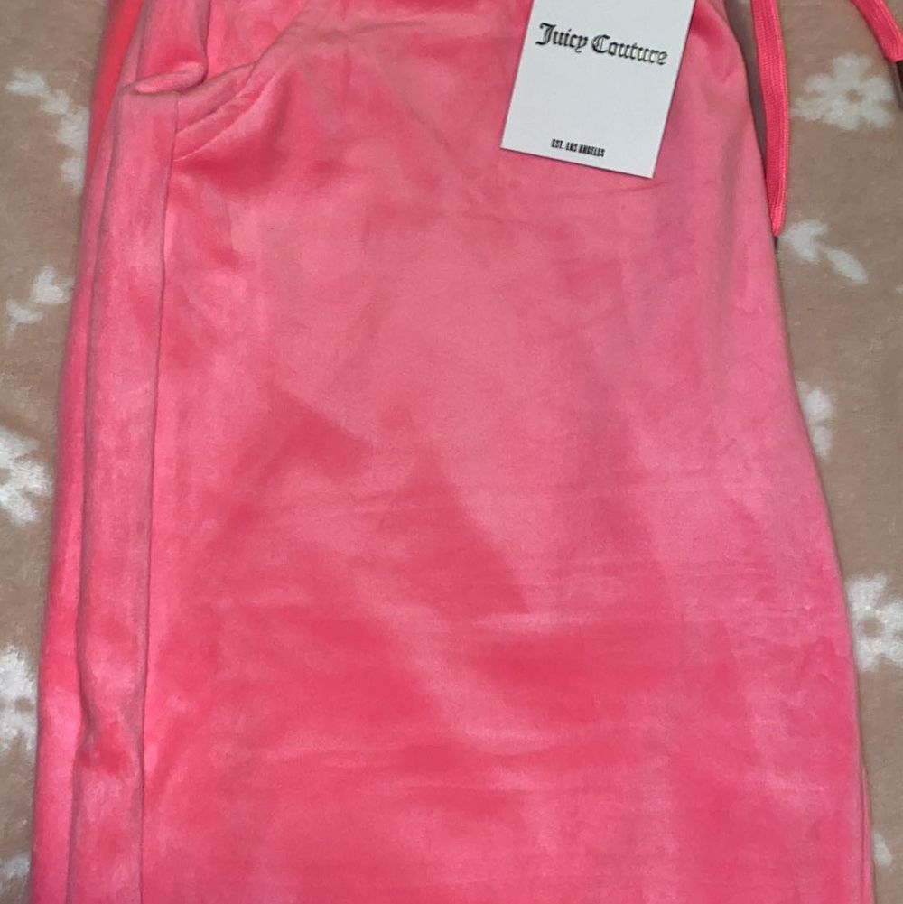 Säljer nu dessa två par Juicy Couture mjukis byxorna. Byxorna är aldrig använda & båda har prislappen kvar, anledningen till varför jag säljer de är för att jag inte haft tiden till att lämna tillbaka dom. Datumet för returen hade gått ut. Byxorna är inte i min storlek och därmed kan någon annan få en användning utav de. Båda byxorna är i storlek (L) Byxorna är i två olika modeller som ni kan se på bilderna. De ljusrosa har resårband i ändarna av byxorna samt fickor men även resårband i midjan. De mörk rosa byxorna är en mer ”vanlig” modell och är utsvängda byxor med vanlig knytning i midjan. Båda byxorna har Juicy couture märket i diamanter på bakdelen. Byxorna är köpta för 1000kr styck & säljs för 700 ( priset kan diskuteras vid snabb affär). Jeans & Byxor.