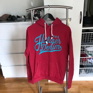 Huvtröja från Tommy Hilfiger Strl M - Huvtröjan Tommy Hilfiger är i medium och bra skick förutom att den har små svarta fläckar på ett fåtal ställen. Vilket är synd för annars är det en snygg tröja, men därav priset. Frakt ingår.