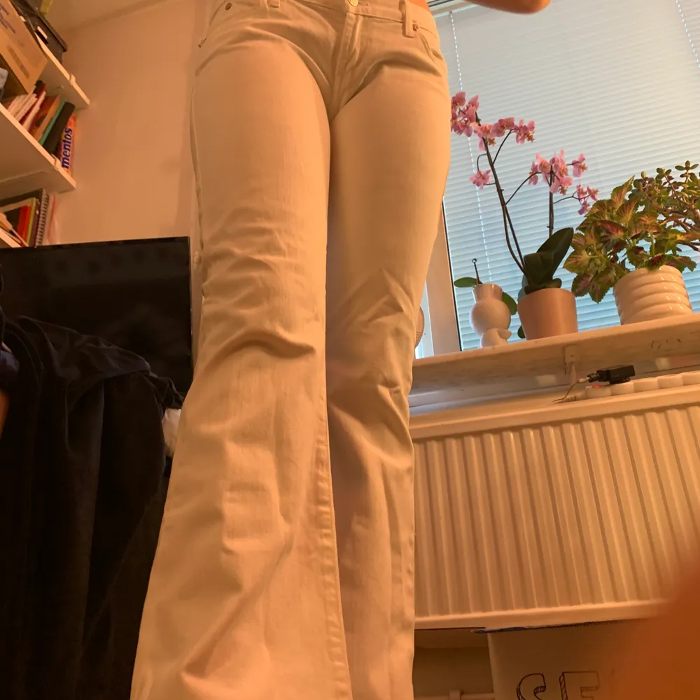 Lågmidjade bootcut Victoria Beckham jeans, vita med blå brodyr på bakfickorna. Ger en väldigt y2k look. Storlek 28x32.. Jeans & Byxor.