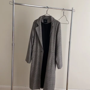 Kappa  - En tunn kappa i fint mönster har en slits på sidan 