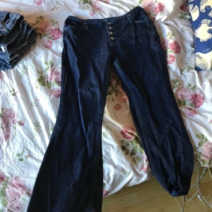 Jätte jätte snygga bootcut jeans - Ett par mörkblå jeans med ljusblå sömmar,använda fåtal gånger men är som i nyskick,köpt på beonretro okså och nypriset ksk låg runt 400