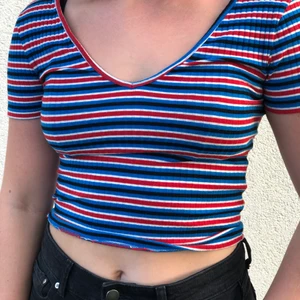 Randig topp - En röd, blå, svart & vit randig topp som är V-ringad både fram och bak, sitter ganska tajt men är såå skön✌🏼 Säljer då den inte kommit till användning