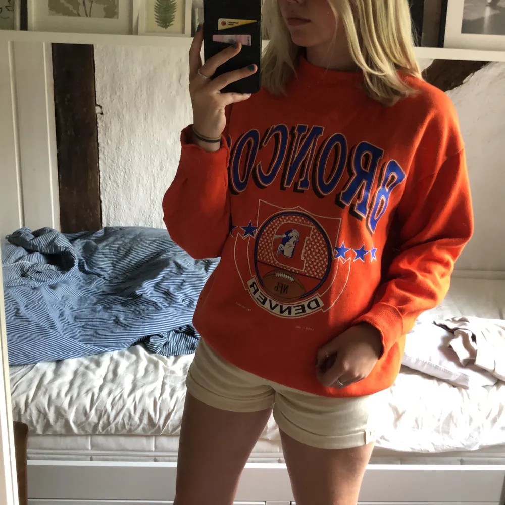 Snygg orange tröja med amerikansk fotboll theme🧡 Från beyond retro men jag köpte den här på plick för 250 kr🧡 aldrig kommit till användning så i bra skick, köparen står för frakt på 66 kr🧡. Tröjor & Koftor.