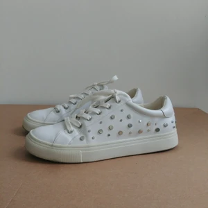 Sneakers med nitdetaljer stl 40 - Vita sneakers i skinnimitation med coola nit-detaljer på sidorna. Endast använda fåtal gånger och därav mycket bra skick