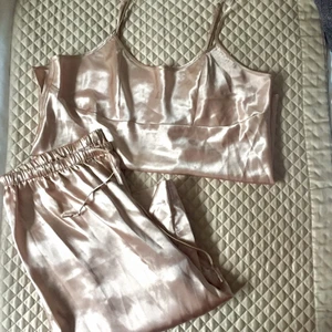 Satin set från my wear - Guldigt/Rosé sidenaktig långbyxa å linne. Passar en S-L då det finns resår i midjan å tyget är ganska luftigt. Hag är 160 och S. Tröjan är 42 cm lång med ljusterbara axelband.