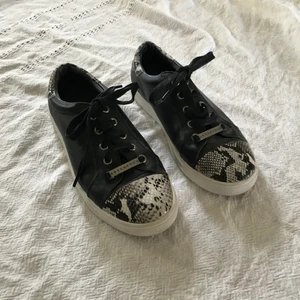 Svarta skor med mönster strl 39 - Svarta skor i fake skinn med gråa ormskinns detaljer. Använda ett fåtal gånger. Perfekta skor om man vill spicea upp en tråkig outfit :)