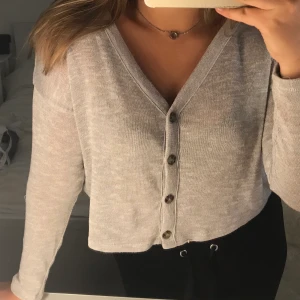 Grå topp - En grå långärmad vanlig tröja, den är lite kortare än vanligt nästan som magtröja :) säljer för 100kr