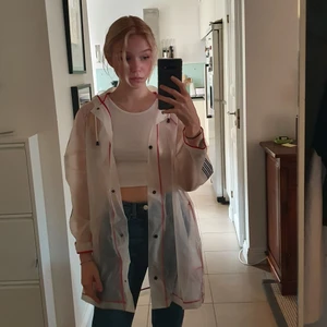 Regnjacka - Genomskinlig regnjacka med röda och svarta detaljer. Från Zara, aldrig använd. Frakt tillkommer, kan även mötas upp i Stockholm.