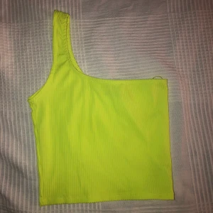Neongu one shoulder - Säljer denna neongula one shoulder linnet pga att den tyvärr inte längre kommer till användning. Den är endast använd 2-3 gånger så nästan helt ny.