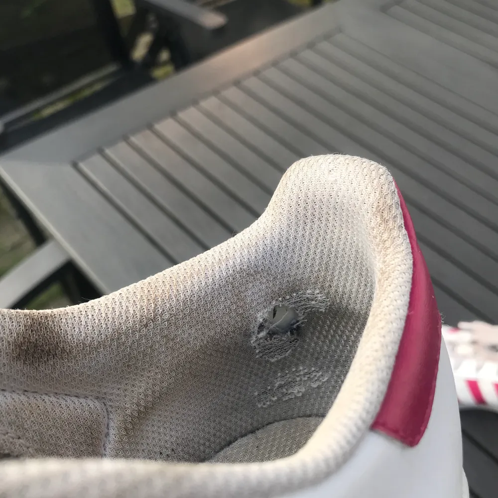 Adidas superstar sneakers med rosa detaljer, strl 39. Använda men i bra skick, enda anmärkningsvärda är att skosnöret och insidan är smutsiga och tyget har skavts upp lite vid insidan på hälarna (se sista bilden).. Skor.