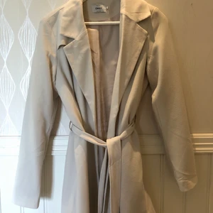 Beige Kappa - Beige kappa från Only använd fåtal gånger i storlek M. Ganska tunn men funkar bra med en tröja under nu på hösten! Lagom i storleken