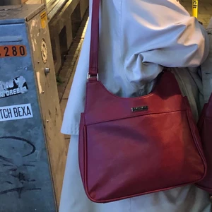 Röd väska - Säljer denna väska igen då jag hade två stycken!!Nice handväska i lädermaterial! Nyskick. Frakten kostar 63kr och är inkluderat i priset :)