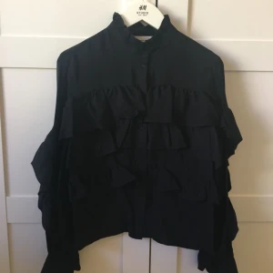  - Volangblus från HM Trend i storlek 36, dock vid i modellen. Använd en gång. Tre volanger framtill samt längs ärmen. Djur finns i hemmet.