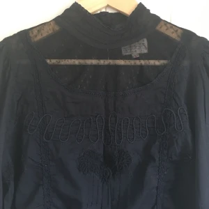  - Svart blus i viktoriansk stil med många detaljer. 100% mjuk bomull. Mycket fint skick. Har fler bilder.