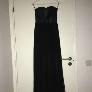  - Svart lång klänning med svart snake print på överdelen. Den har inga armar och ser väldigt snygg ut. Den har en slits på varje sida som gör den ännu snyggare :)