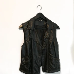  - Väst i skinnimitation.