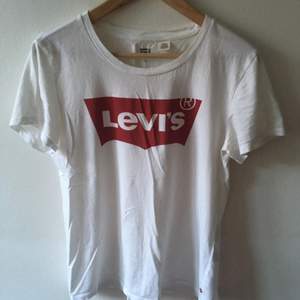 Vit t-shirt med rött Levi’s tryck. Sparsamt använd, skulle gissa max 5 gånger. I mycket fint skick! Frakt ingår!