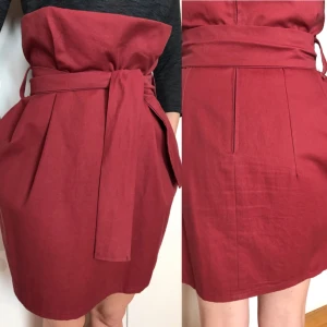  - Kjol i vinrött, knyt i midjan, dragkedja bak. Fickor.  Nyskick. Använd någon enstaka gång.   Inte märkt med storlek, men jag har normalt strl 36. Kan även passa 38. 