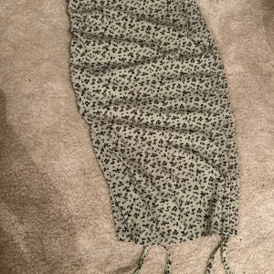 Lång kjol - Right lång kjol med snörning på båda nedre som man kan dra åt för att justera kjolens längd. Ribbad i materialet. Åtsittande. 