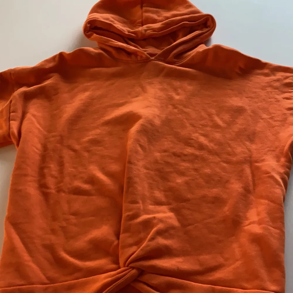En fin orange färgad tröja med en knut längst ner och passar till mycket. Den är i mycket bra skick.. Hoodies.
