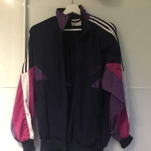 Adidas kofta med lila, rosa och mörkblå design. Jag har oftast M och skulle säga att den här passar mig ganska perfekt. Köpt på Humana. Pris kan diskuteras