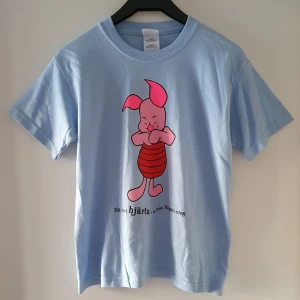 Vintage ljusblå t-shirt med Nasse - Vintage ljusblå t-shirt med Nasse. Storlek ungdoms S, passar ca storlek XS/S och kanske en liten M. Fraktkostnad blir 45kr. OBS! Budgivning, kommentera jättegärna bud om du är intresserad (med höjning på minst 5kr och exkl. frakt) tack! 😊 sluttid torsdag kl 18:10!