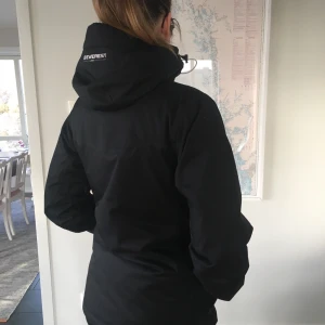 Everest skidjacka svart - Everest skidjacka i svart med vita detaljer, bra skick. Svart kraftigt yttertyg, även midjeknäppning på insidan. Perfekt för skidåkning. Ev frakt tillkommer med ca 60 kr. Storleken är 36 men jackan är rymlig. 