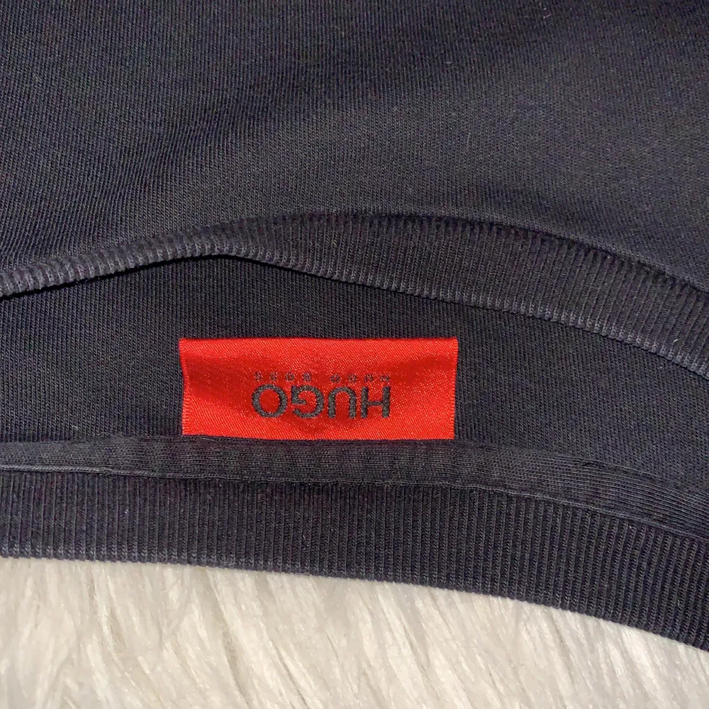 Svart Hugo Boss Sweatshirt med röd logga med texten ”HUGO”. Använder ej längre och den har även blivit för liten, nypris 999:-. Tröjor & Koftor.
