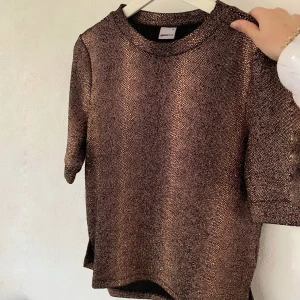 GinaTricot tröja  - Jättefin guldglittrig tröja från GinaTricot, storlek M. Använd fåtal gånger, alltså i bra skick. Passar perfekt nu till jul och nyår🎉 80kr plus frakt. Skriv för mer info och bilder:)