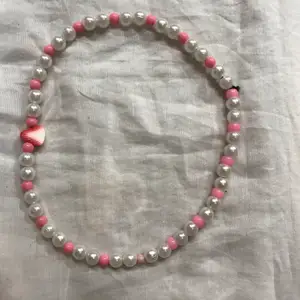jättegulligt halsband med rosa och vita pärlor och en jordgubbe. Gjord av stretchig tråd:) frakt på 20 kr tillkommer, samfraktar!  dma vid frågor/intresse💗💗
