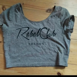 Jättesnygg Rebel club croptop  - Oanvänd. Snyggt brun/grå melerad. Sitter tajt och snyggt! Djur och rökfritt hem. Frakt tillkommer på 44:- Jag samfraktar gärna!