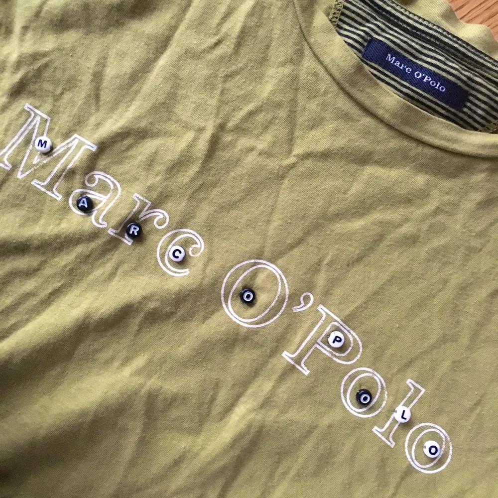 Grön T-shirt från märket Marco Polo med ”bokstavspärlor” som jag sytt på själv. !Frakt ingår!. T-shirts.