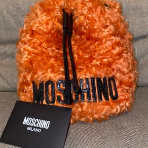 Moschino väska - Nypris 4200kr, säljer för 2500kr. Använd 1 gång, äkthetsbevis medföljer och det finns både axelband och handledsband som är avtagbara. 