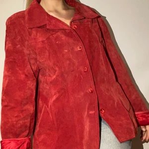 Röd mockajacka - Säljer min fina mockajacka som köptes second hand för ett par år sen. Den är knappt använd och i jättefint skick! I stl 50, men skulle uppskatta den till M/L. Jag är oftast S men gillar hur den sitter lite löst ändå. 