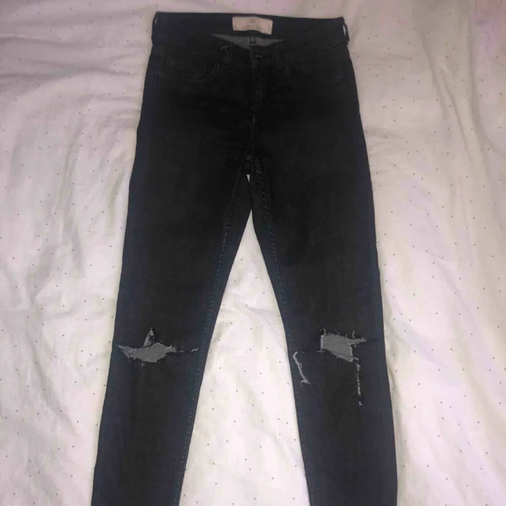 Svarta jeans med slitningar på knäna. Helt ok skick med en liten fläck som syns på tredje bilden, inte helt säker på om den försvinner därav priset.. Jeans & Byxor.
